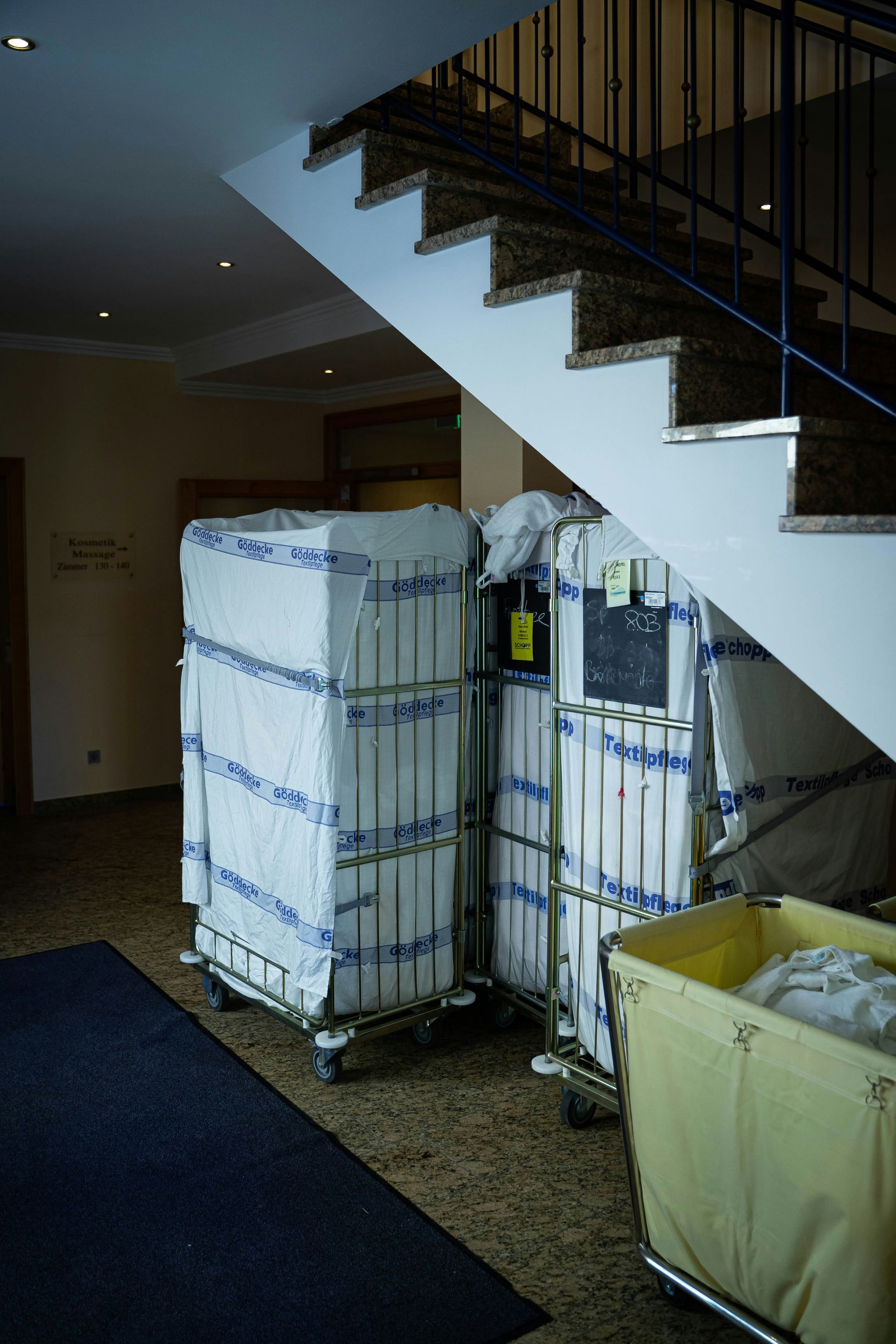 a room with a staircase and a few bins